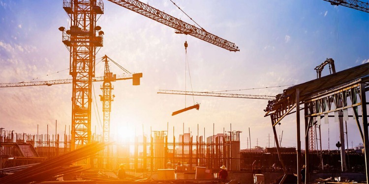 Fotografia di un cantiere e delle gru al tramonto.