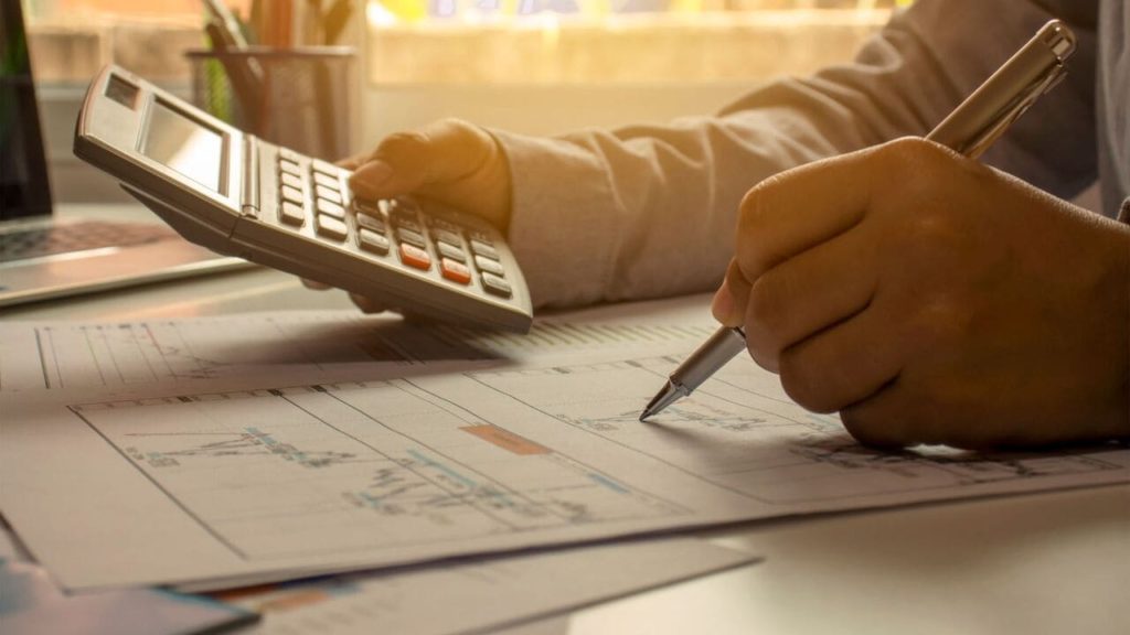 Revisore analizza i bilanci di un'azienda per rilasciare l'attestazione di capacità finanziaria.